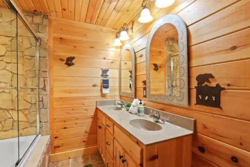 Elegant bathroom on the main level with double sinks and high-end stonework and jetted jacuzzi tub/ shower.